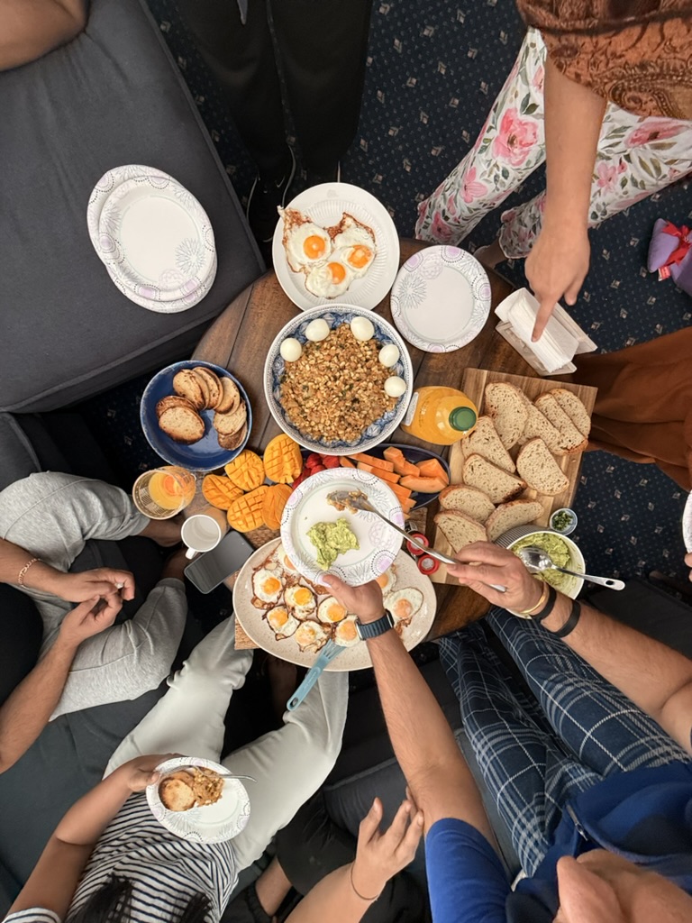 Family-style breakfast spread with fruit, pastries, and eggs