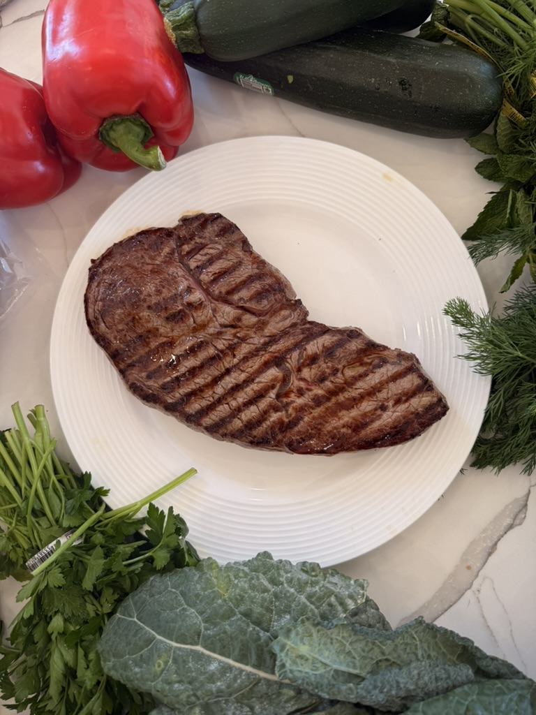 Grilled steak with charred peppers, zucchini, and fresh herbs